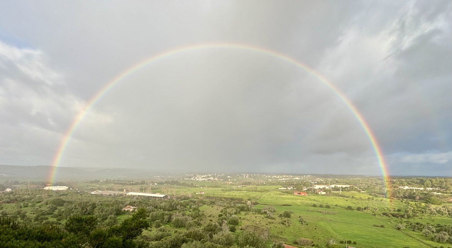Um arco-íris completo sobre os campos verdes do Chinicato